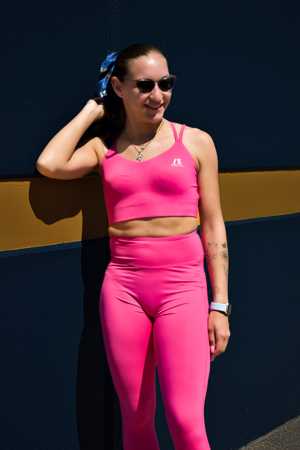 white model wearing inspr exchange athletica pink navigator sports bra and leggings set with pockets