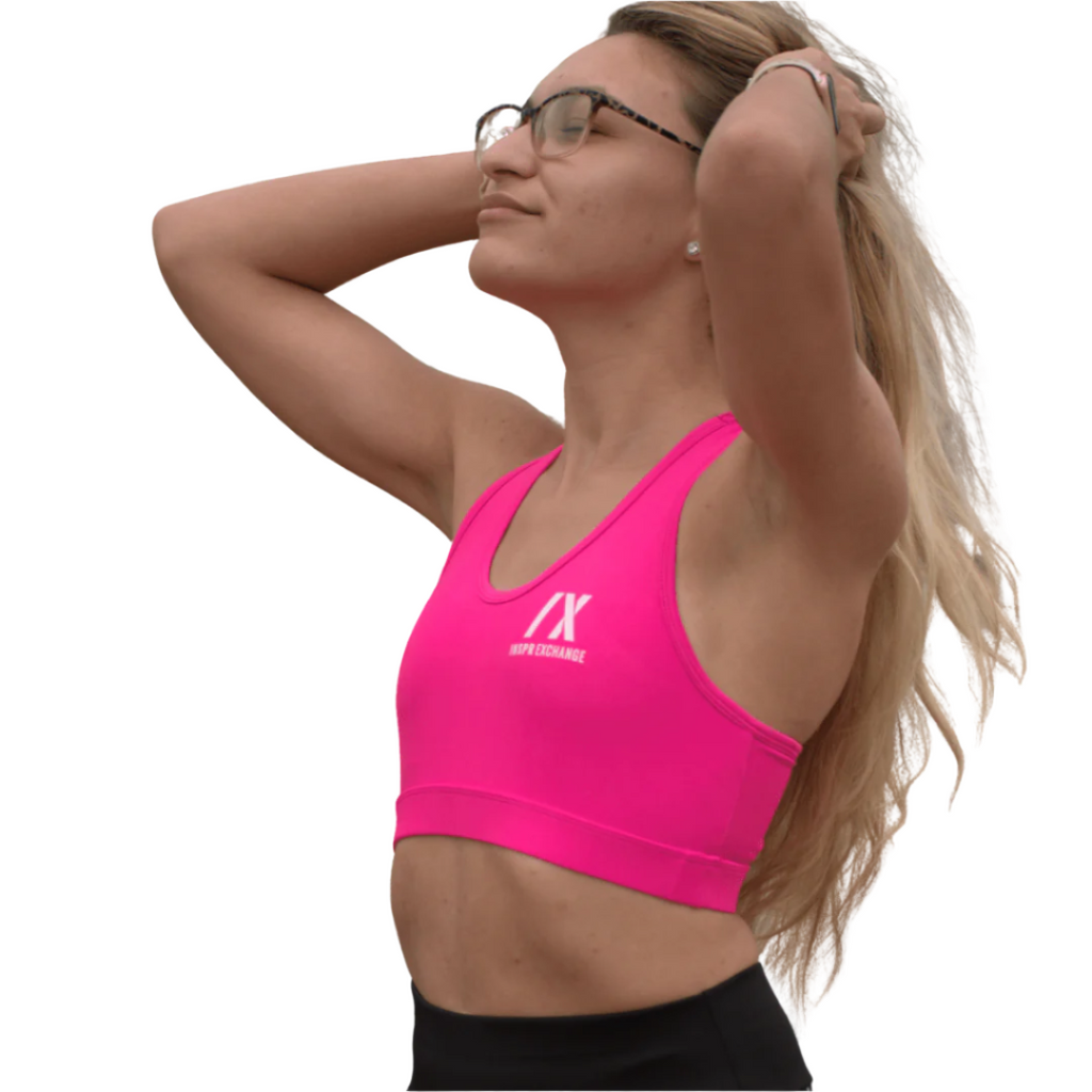 female athletic model posing for inspr exchange athletica while wearing pink virago sport bra with black leggings
