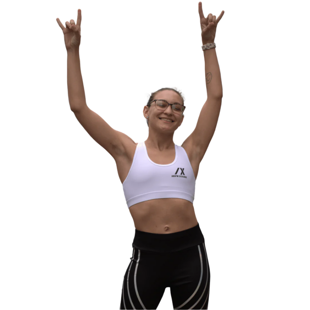 female athletic model posing for inspr exchange athletica while wearing white virago sport bra with black leggings