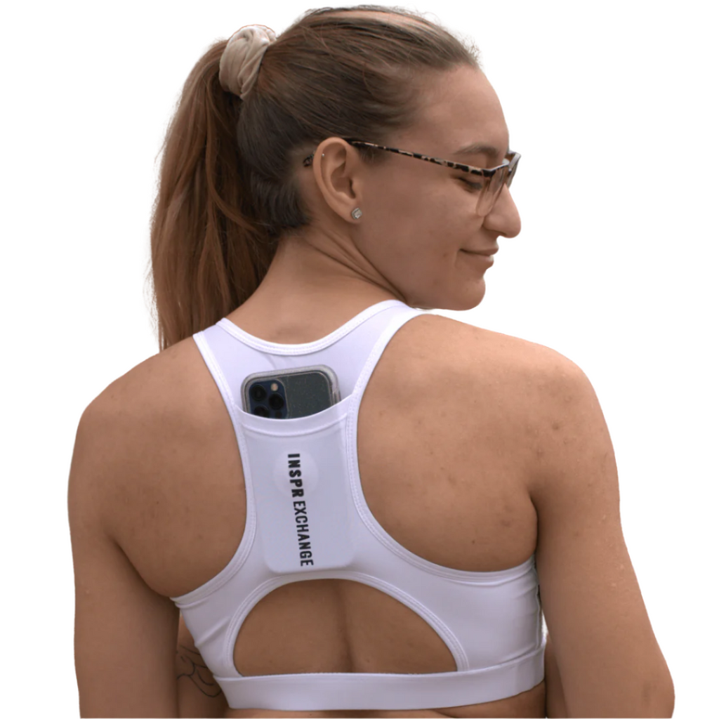 female athletic model posing for inspr exchange athletica while wearing white virago sport bra with black leggings